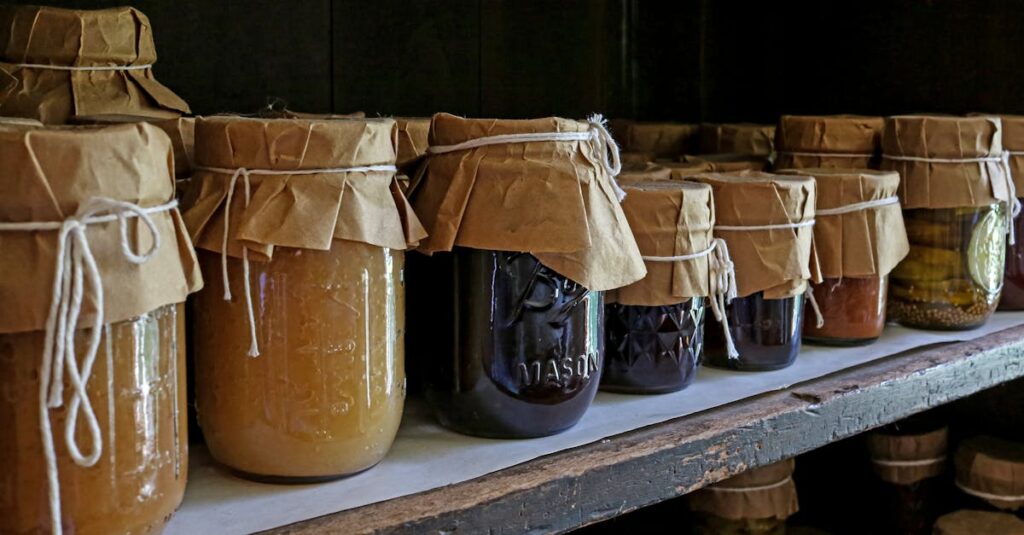 Assorted preserved foods in glass jars on a wooden shelf, showcasing traditional storage methods.